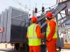 electricians standing next to a transformer in electrical power plant