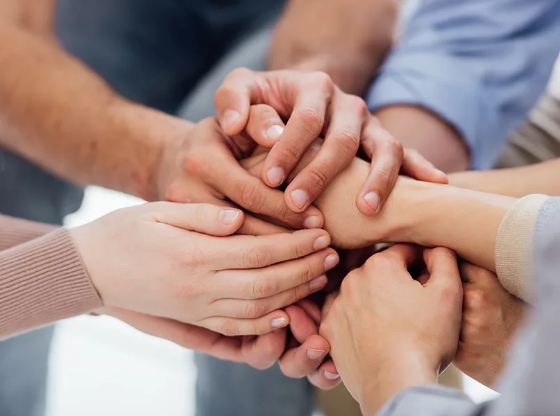 cropped view of people stacking hands during group therapy session