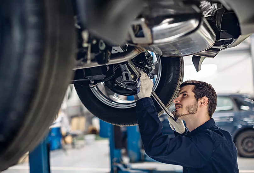 Auto car repair service center. Mechanic examining car suspension