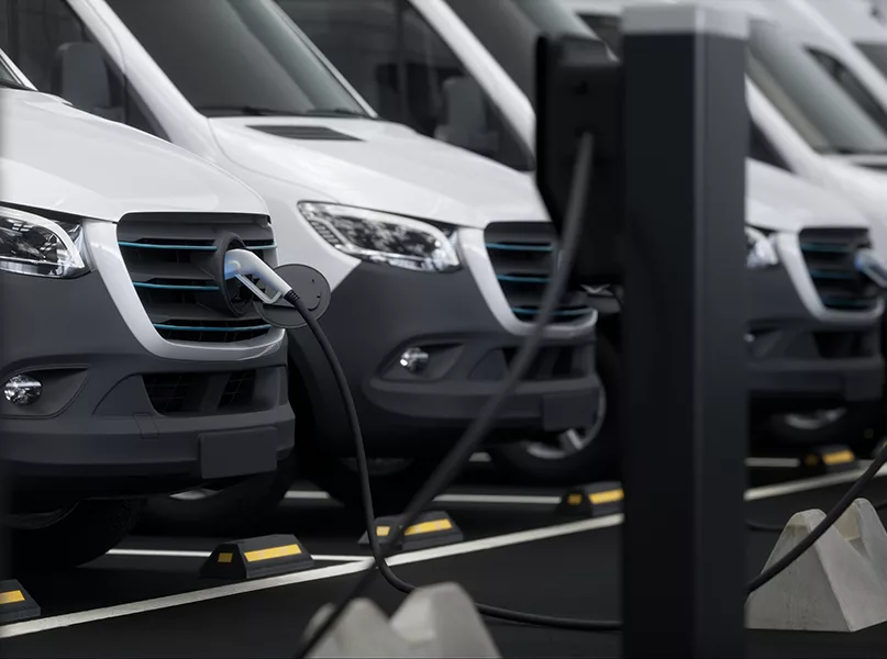 CU Fleet of generic electric EV delivery vans charging on charging stations inside company parking garage